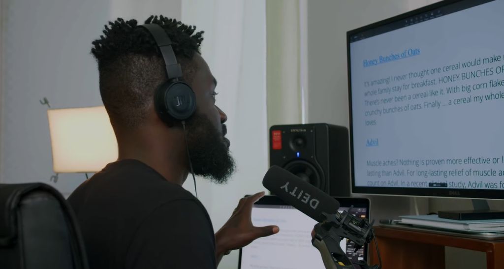 A voiceover artist reading his script in his studio setup