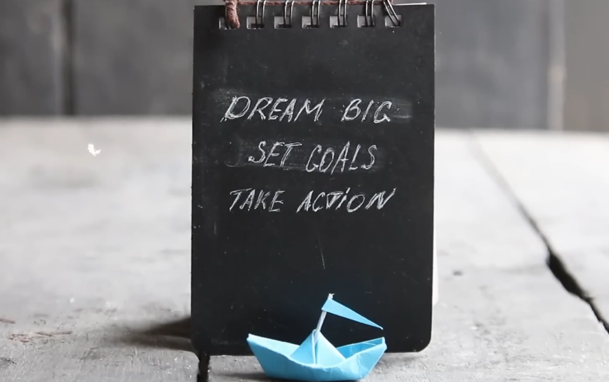 An image of a book cover featuring the motivational phrase dream big, set goals, take action.